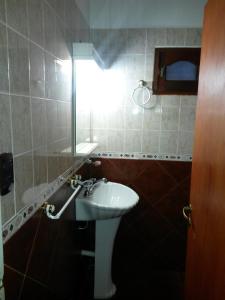 a bathroom with a sink and a mirror at Complejo Cabañas Foxes Frente al Lago in Villa del Dique