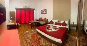 um quarto com uma cama grande e um cobertor vermelho em The Sultan Resort em Kulan