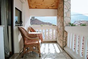 d'un balcon avec deux chaises, une table et une fenêtre. dans l'établissement Apartment Ikar, à Mostar