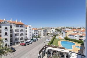 Blick auf eine Stadtstraße mit Gebäuden und einem Pool in der Unterkunft Apartamento Caju by Algarve Holidays in Albufeira