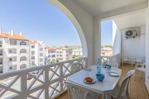 einen Balkon mit einem Tisch und Stühlen sowie Stadtblick in der Unterkunft Apartamento Caju by Algarve Holidays in Albufeira