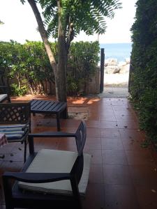 チッタデッラ・デル・カーポにあるB&B Villa Gubitosiの海辺の歩道に座る二つのベンチ