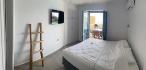 a bedroom with a bed with a ladder in it at Windmill House Antiparos in Soros
