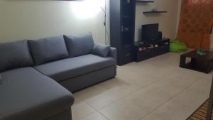 a living room with a blue couch and a tv at Plaza 305 Albufeira in Albufeira +3 photos