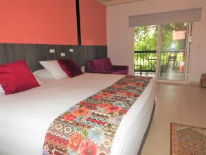 a hotel room with a large bed and a window at Villa Juana Hotel in Pereira