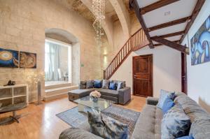 a living room with two couches and a table at UNIQUE Waterfront Valletta House in Valletta