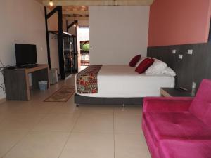 a bedroom with a bed and a couch at Villa Juana Hotel in Pereira