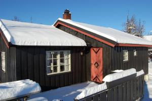 a small cabin with snow on the roof at Torsetlia Cottages and Apartments in Uvdal