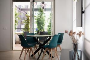 ein Esszimmer mit einem Tisch und grünen Stühlen in der Unterkunft Casa Scalzi in Rom