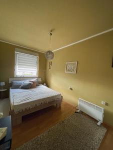 a bedroom with a bed and a window at Stan na dan Apartman Stella in Sombor