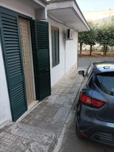a car parked next to a building with green doors at Dimora Kailia in Ceglie Messapica