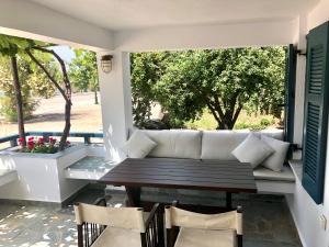 - une terrasse couverte avec un canapé, une table et des chaises dans l'établissement SAIL house, à Skala Kallirakhis