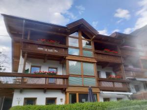 a building with wooden balconies and flowers on it at Haus Anna Lena in Längenfeld