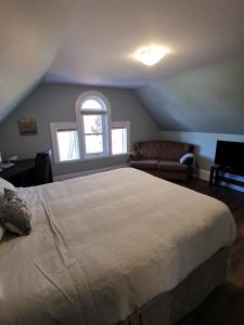 - une chambre avec un grand lit et un canapé dans l'établissement By The River B&B, à Fredericton