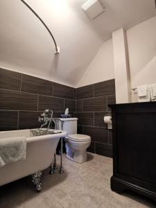 a bathroom with a bath tub and a toilet at By The River B&B in Fredericton