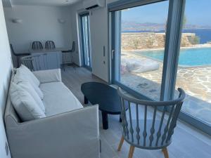 a living room with a couch and a large window at Windmill House Antiparos in Soros