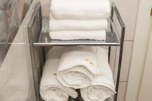 un portasciugamani con asciugamani bianchi in un armadio di Central 10 a Oradea