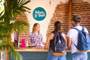 Un groupe de trois personnes debout à un comptoir dans l'établissement Bohemia Beach, à Guachaca