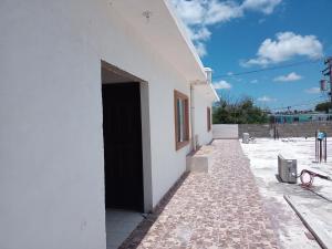 biały budynek z czarnymi drzwiami na boku w obiekcie LOSSANTOS w mieście Matamoros