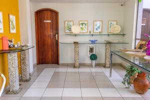 a hallway with a table and a wooden door at Pousada Boulevard in Cabo Frio +37 photos