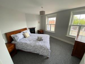 a bedroom with a bed with a teddy bear on it at Oyster Catchers in Ryde