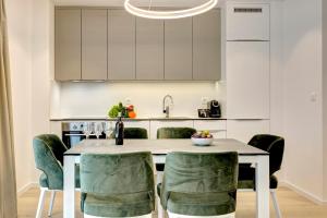 a kitchen with a table with green chairs at Four Blue Seasons - Luxury Apartments Dubrovnik in Dubrovnik
