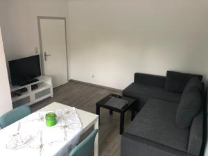 salon z kanapą i stołem w obiekcie Ferienwohnung an der A7 w mieście Northeim