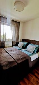 a bedroom with a large bed and a window at Apartman VARENICA in Doboj