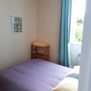 a bedroom with a bed and a chair and a window at Chambres d'hotes Condat in Condat-sur-Ganaveix