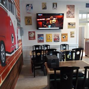 a restaurant with tables and a tv on the wall at Chambres d'hotes Condat in Condat-sur-Ganaveix