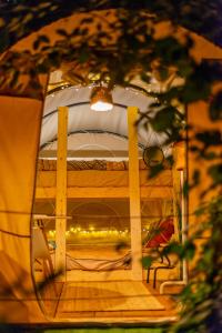 a view through a mirror of a room with a bed at Dragonfly Gardens Urban Glamping Brasov in Braşov