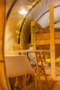 een ronde kamer met een tafel en een stoel in een tunnel bij Dragonfly Gardens Urban Glamping Brasov in Braşov