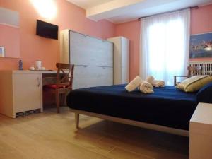 a bedroom with a bed and a desk and a window at Affittacamere Porticciolo in Castelnuovo del Garda