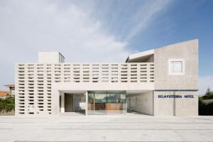 un gran edificio blanco con un cartel. en Hotel Bela Fisterra, en Finisterre