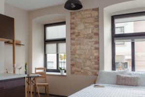 a bedroom with a bed and a stone wall at Pod Jasną 28 in Częstochowa
