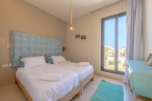a bedroom with a bed and a large window at La Casa de Playa Tawila on Island 4BR Private with Heated Pool in Hurghada