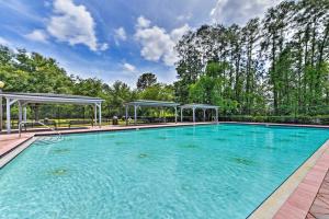 a large swimming pool with blue water at Jax Home with Yard - 10 Mi to Adventure Landing! in Jacksonville