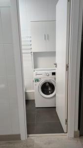 uma máquina de lavar e secar roupa branca num pequeno quarto em A casa de Mateo em Ribadavia