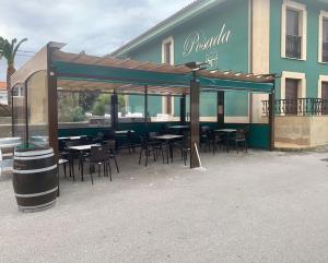 a restaurant with tables and chairs in front of a building at posada carral cabarceno in La Concha