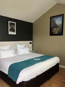 a bedroom with a large bed with a blue blanket at Hôtel les 13 Assiettes in Le Val-Saint-Père