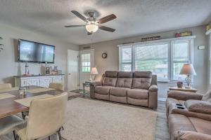 a living room with a couch and a dining room at Cheerful Camdenton Cottage Steps to Lake! in Camdenton