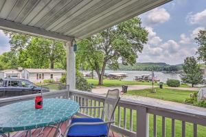 a porch with a table and chairs and a view of the water at Cheerful Camdenton Cottage Steps to Lake! in Camdenton