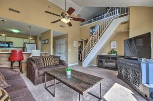 a living room with a couch and a tv at Osage Beach Condo with Shared Pool and Lake Views! in Osage Beach