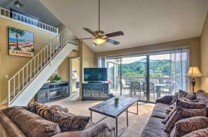 a living room with a couch and a tv at Osage Beach Condo with Shared Pool and Lake Views! in Osage Beach