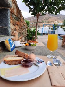 una mesa con un plato de comida y un vaso de zumo de naranja en Studio Elisabeth, en Agios Ioannis