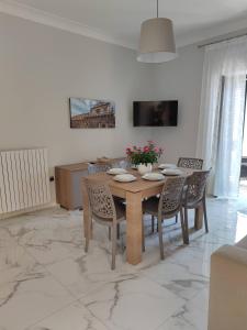 cocina y comedor con mesa y sillas en Kalos Casa Vacanza, en Salice Salentino