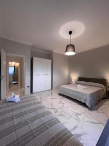 1 dormitorio con 1 cama y suelo de mármol grande en Kalos Casa Vacanza, en Salice Salentino