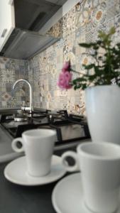 a kitchen with two cups and a vase on a counter at Kalos Casa Vacanza in Salice Salentino