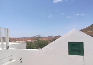 uma janela verde do lado de um edifício branco em Nos Kasa Povoaçao Velha em Cabeçadas