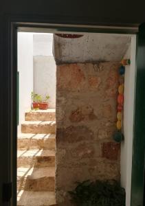 eine offene Tür mit einer Steinmauer und einer Treppe in der Unterkunft Nos Kasa Povoaçao Velha in Cabeçadas